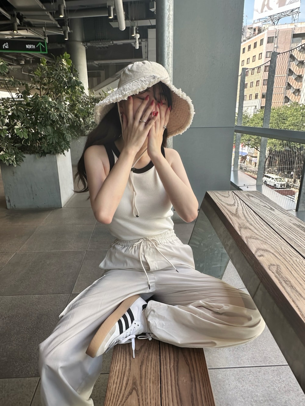 ホワイト系のタンクトップ、ホワイト系のカーゴパンツ、ホワイト系のスニーカーを着用したレディースの夏コーディネートの2枚目の写真