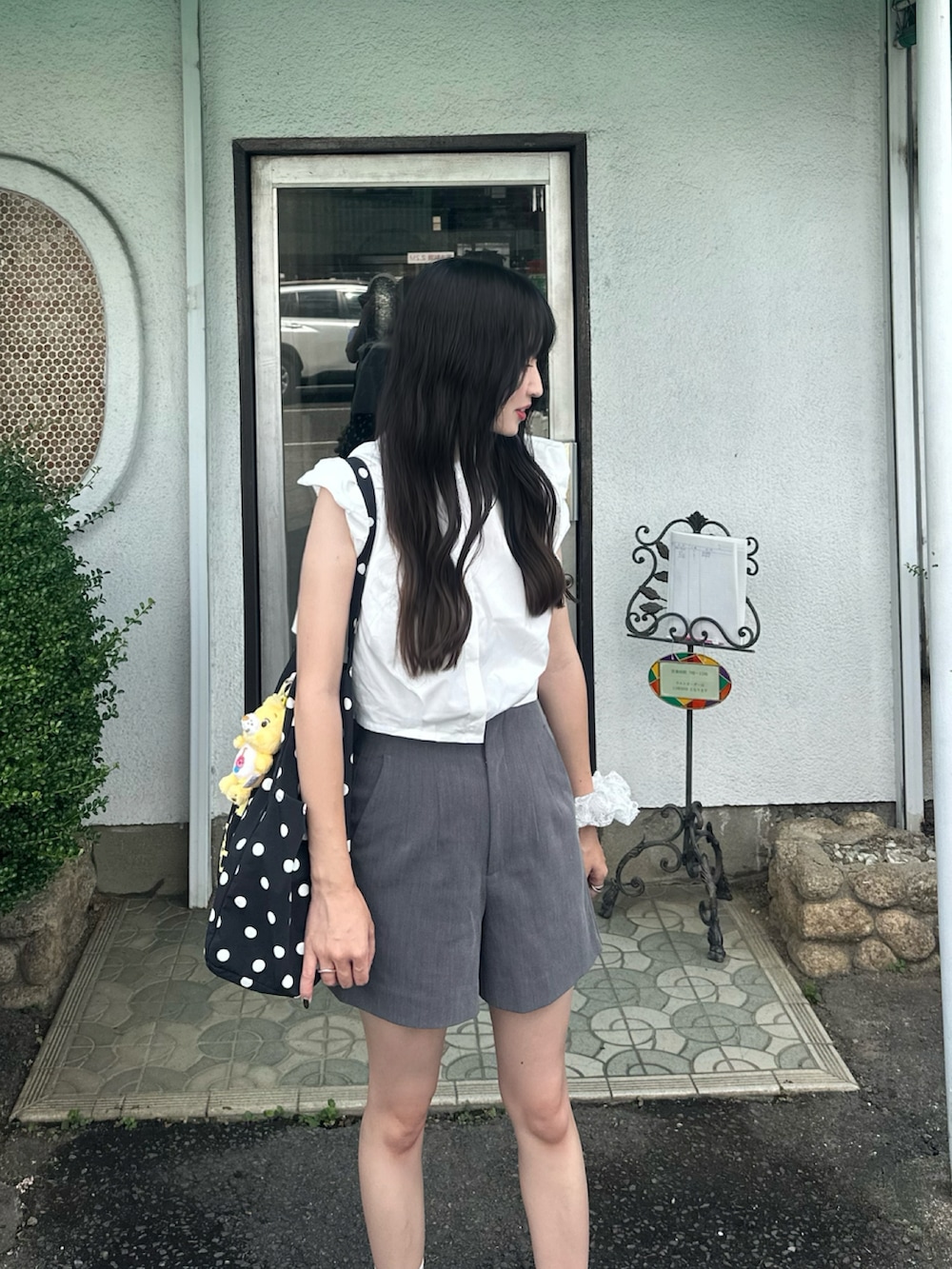 ホワイト系のシャツ/ブラウス、グレー系のパンツ、ブラック系のトートバッグを着用したレディースの夏コーディネートの2枚目の写真