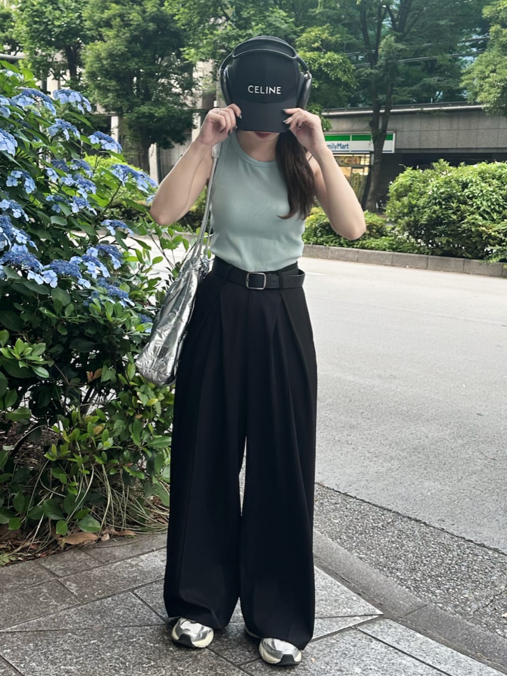 ホワイト系のスニーカー、ブルー系のタンクトップ、ブラック系のスラックスを着用したレディースの夏コーディネートの2枚目の写真