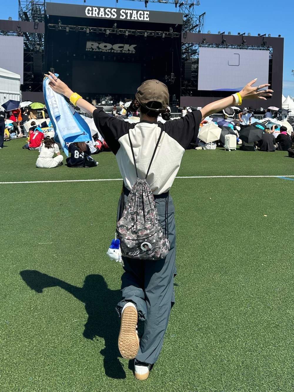 ブラック系のTシャツ/カットソー、グリーン系のバックパック/リュック、グレー系のカーゴパンツを着用したレディースの夏コーディネートの2枚目の写真