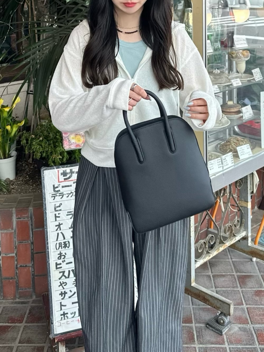 ブルー系のタンクトップ、ホワイト系のジャケット/アウター、グレー系のパンツを着用したレディースの春コーディネートの2枚目の写真