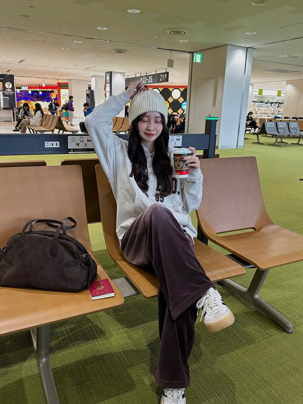 ベージュ系のパーカー、ブラウン系のその他パンツ、ホワイト系のスニーカーを着用したレディースの秋コーディネートの2枚目の写真