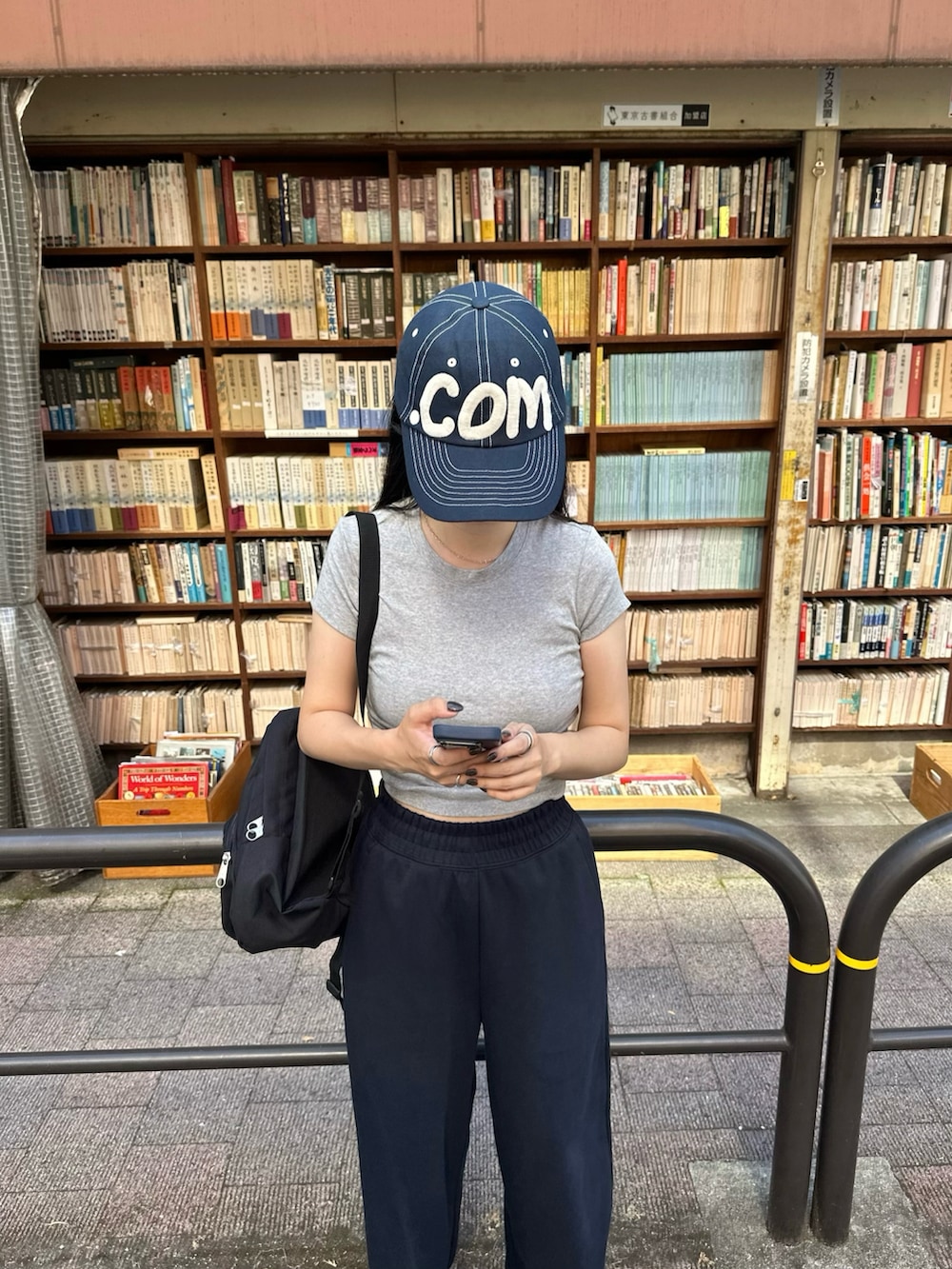 ブラック系のバックパック/リュック、グレー系のTシャツ/カットソー、ブルー系のスウェットパンツを着用したレディースの夏コーディネートの2枚目の写真