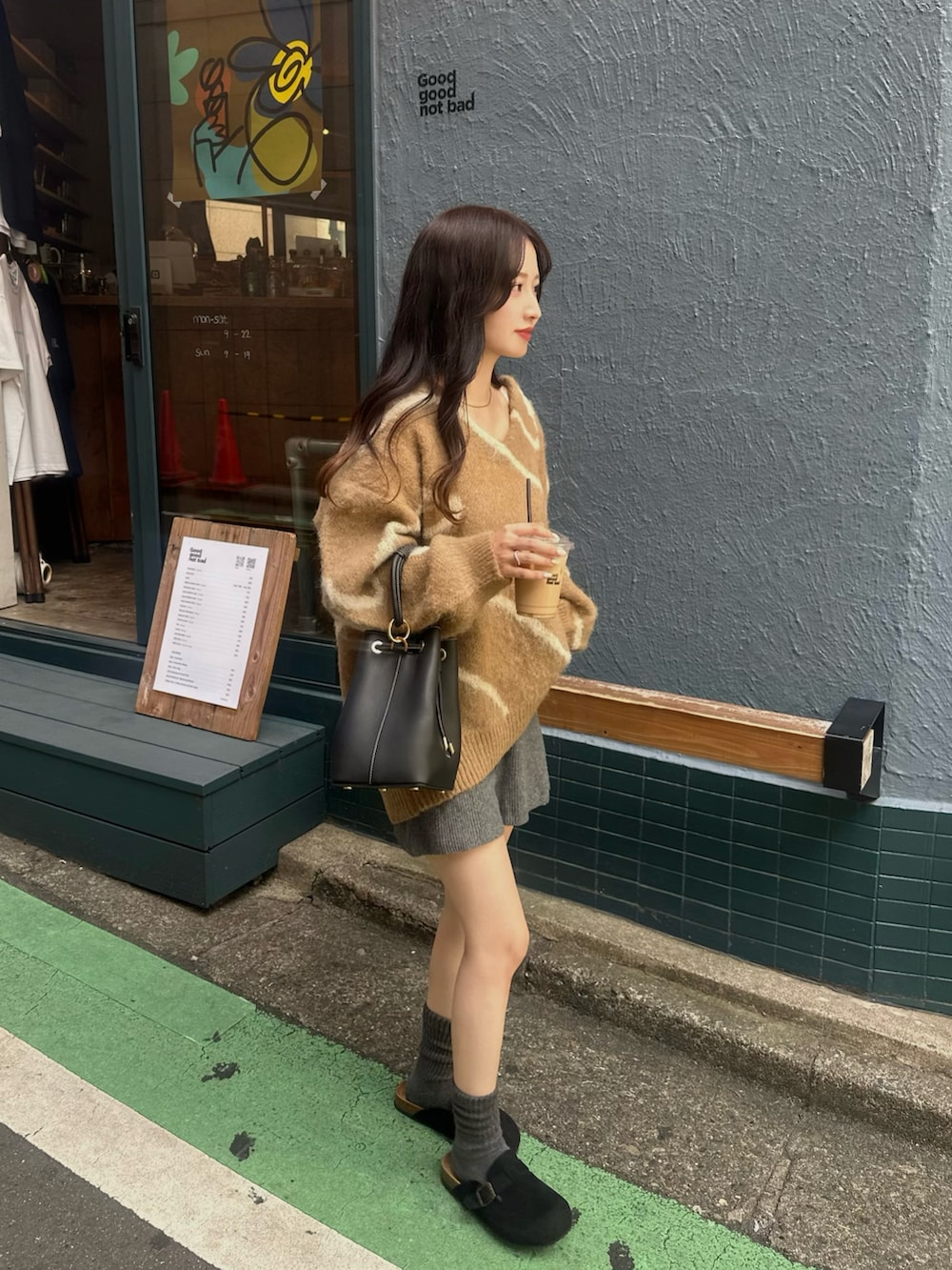 ブラウン系のニット/セーター、グレー系のその他パンツ、ブラック系のハンドバッグを着用したレディースの秋コーディネートの2枚目の写真