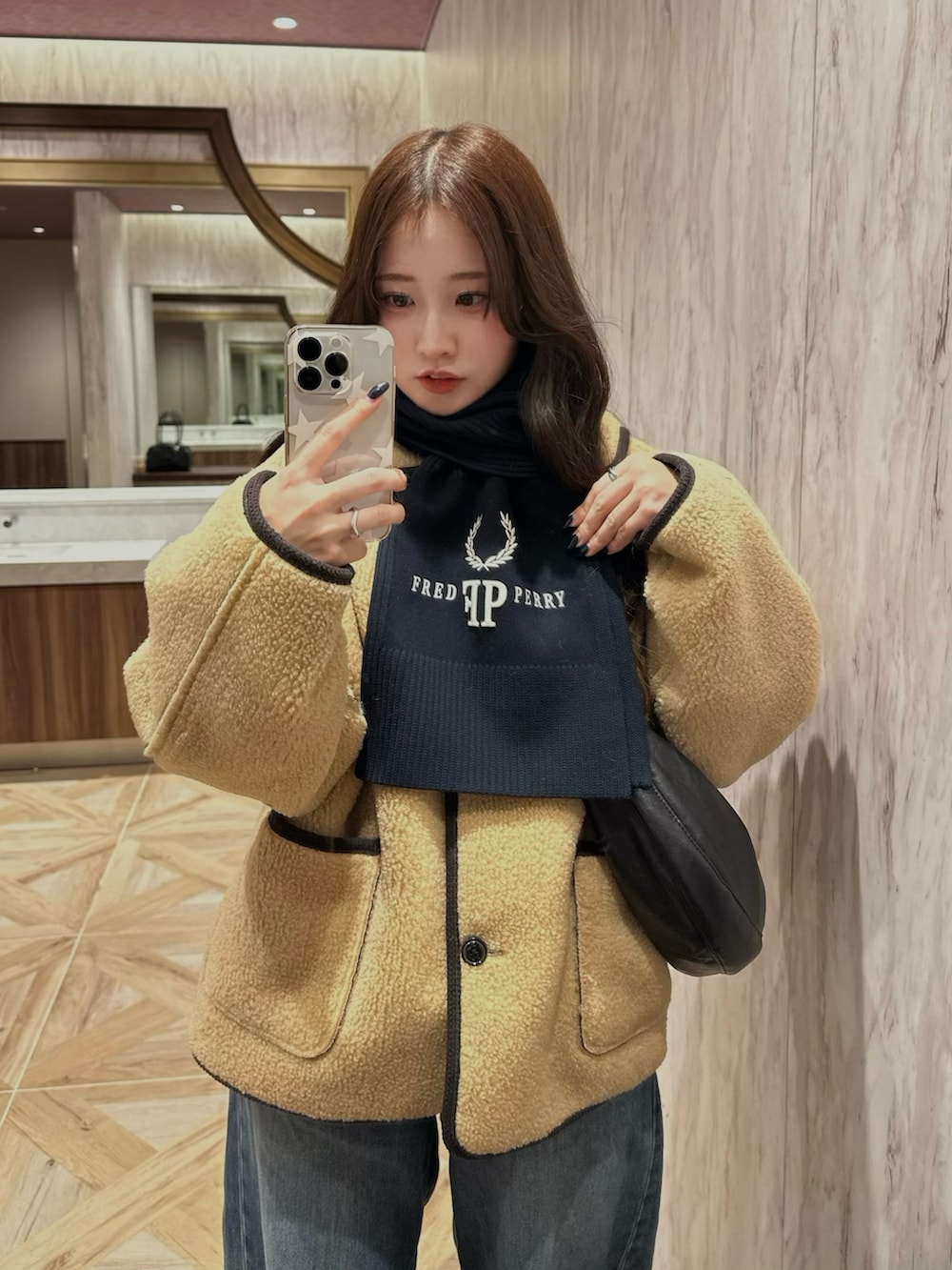 ベージュ系のジャケット/アウター、ブルー系のデニムパンツ、ブラック系のショルダーバッグを着用したレディースの冬コーディネートの2枚目の写真