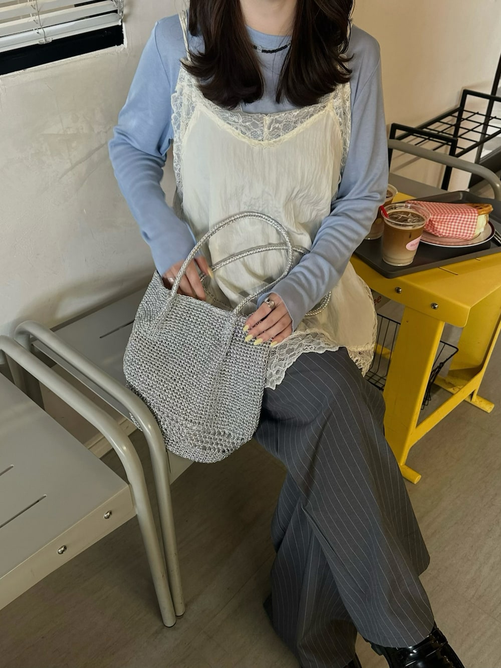 ホワイト系のキャミソール、グレー系のスラックス、ブラック系のローファーを着用したレディースの春コーディネートの2枚目の写真
