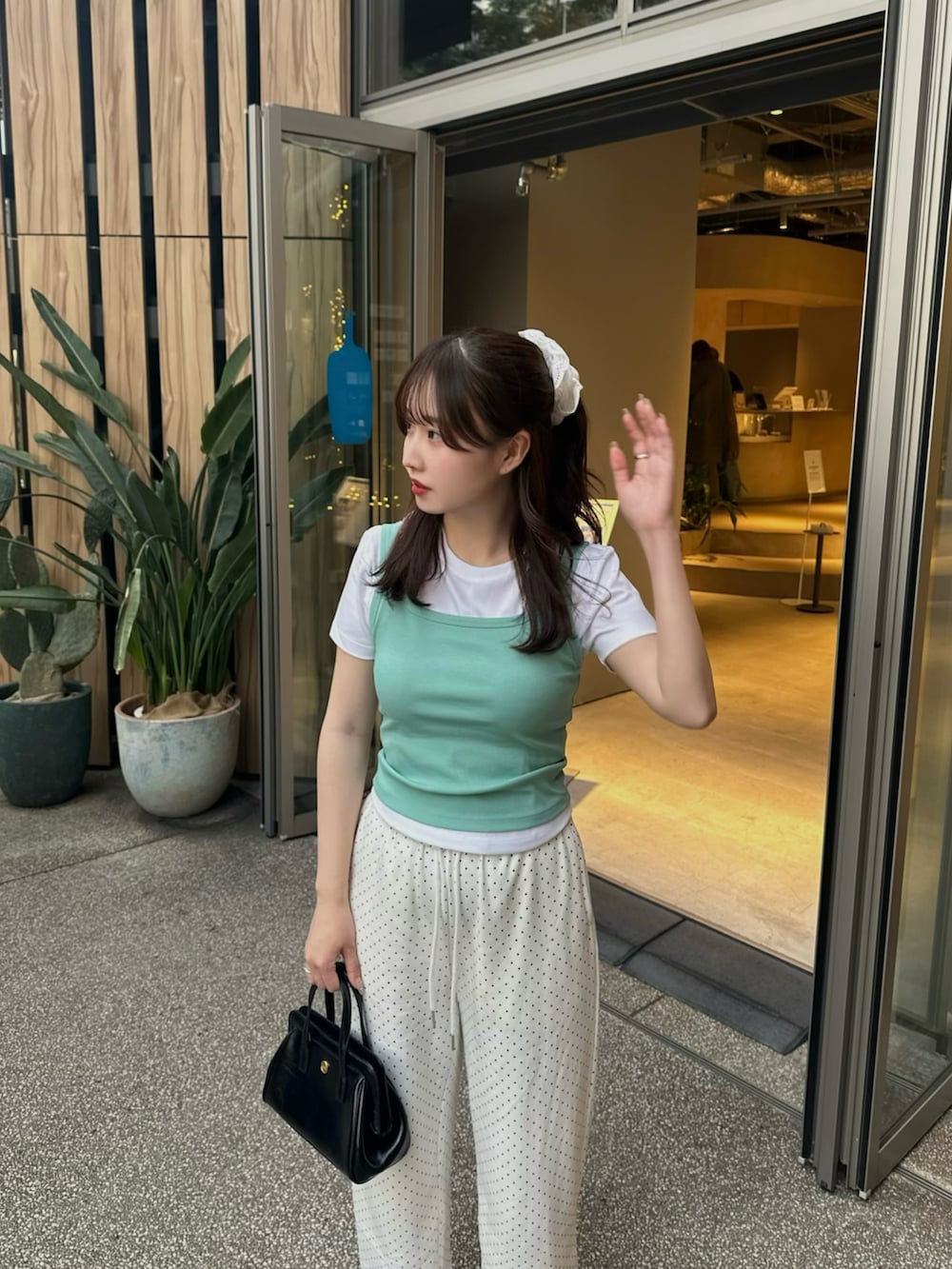 ホワイト系のスウェットパンツ、ブラック系のサンダル、グリーン系のトップスを着用したレディースの夏コーディネートの2枚目の写真