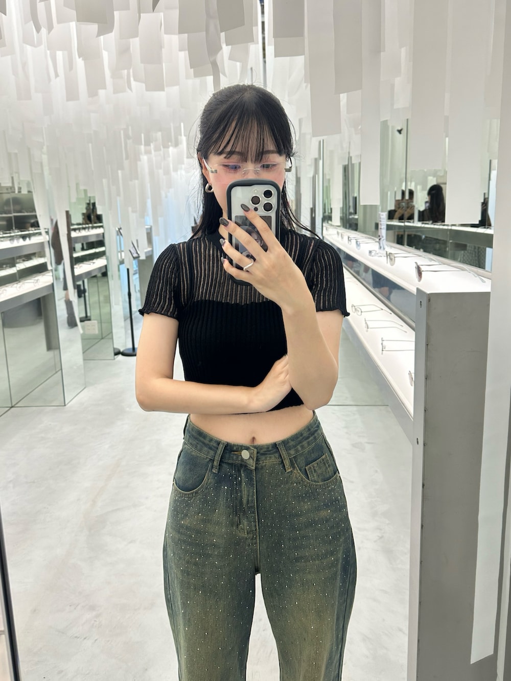 ブルー系のデニムパンツ、ブラック系のTシャツ/カットソー、ブラック系のブーツを着用したレディースの夏コーディネートの2枚目の写真