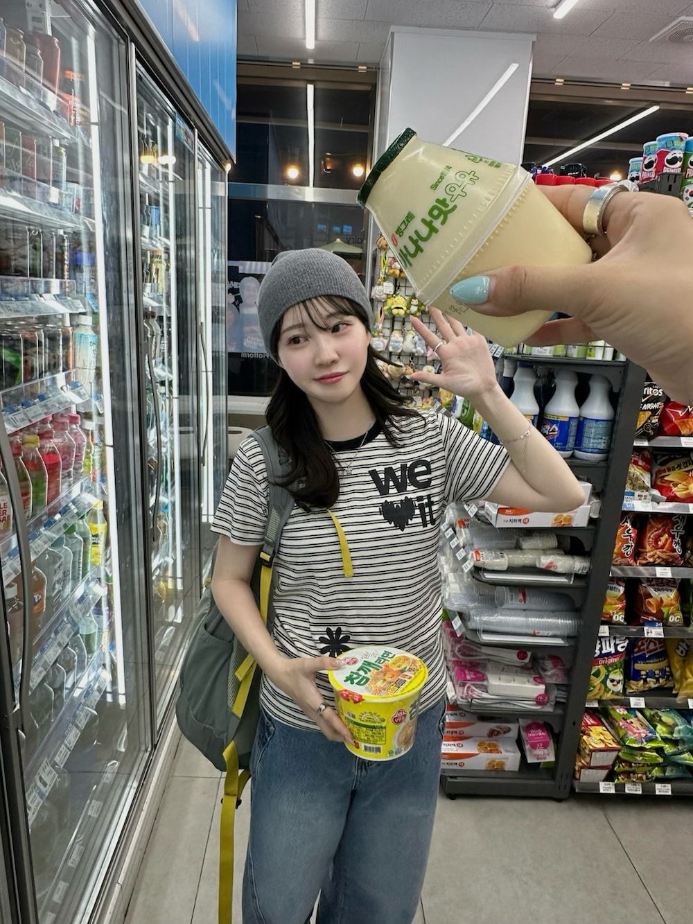 ブルー系のデニムパンツ、グレー系のバックパック/リュック、ホワイト系のTシャツ/カットソーを着用したレディースの春コーディネートの2枚目の写真