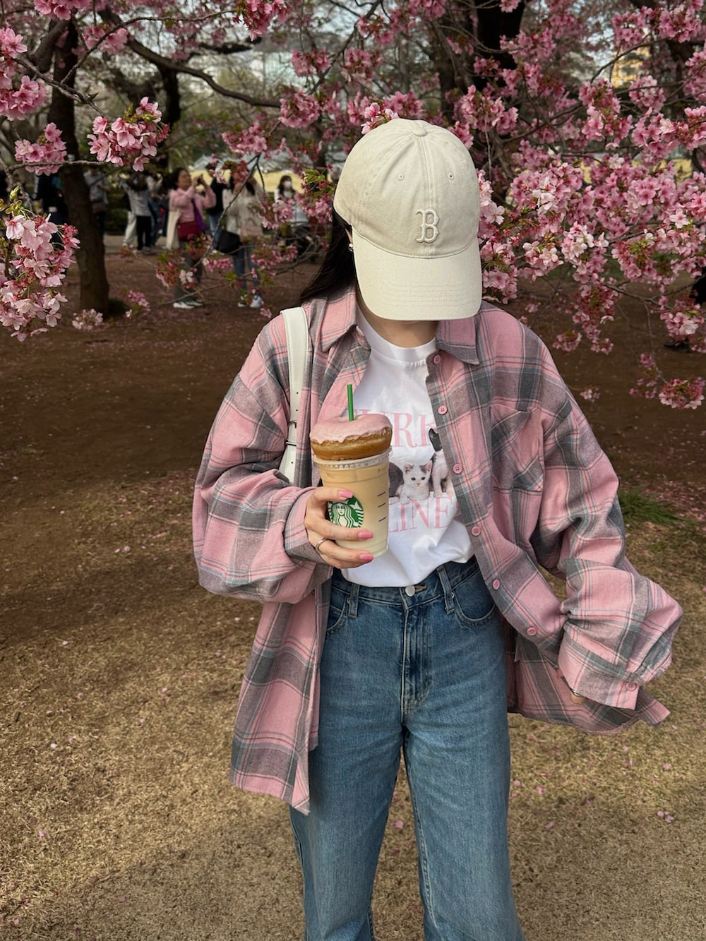 ピンク系のシャツ/ブラウス、ブルー系のデニムパンツ、ホワイト系のバッグを着用したレディースの春コーディネートの2枚目の写真