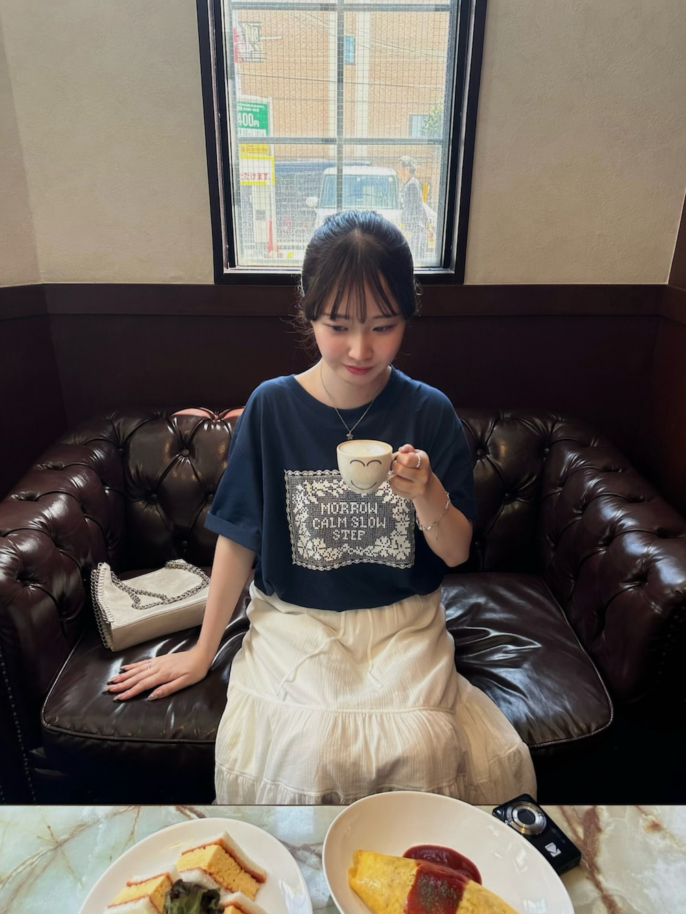ブラック系のローファー、ブルー系のTシャツ/カットソー、ホワイト系のスカートを着用したレディースの春コーディネートの2枚目の写真