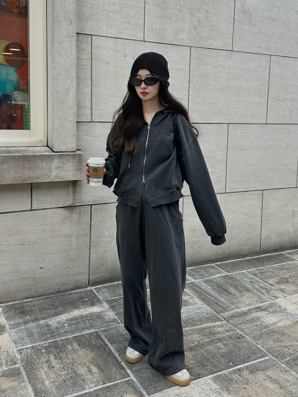 グレー系のパーカー、グレー系のスウェットパンツ、グリーン系のバックパック/リュックを着用したレディースの秋コーディネートの2枚目の写真