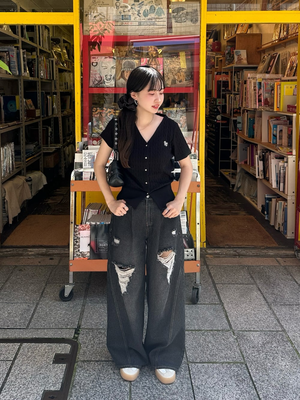 ブラック系のカーディガン/ボレロ、ブラック系のデニムパンツ、ブラック系のバッグを着用したレディースの夏コーディネートの2枚目の写真