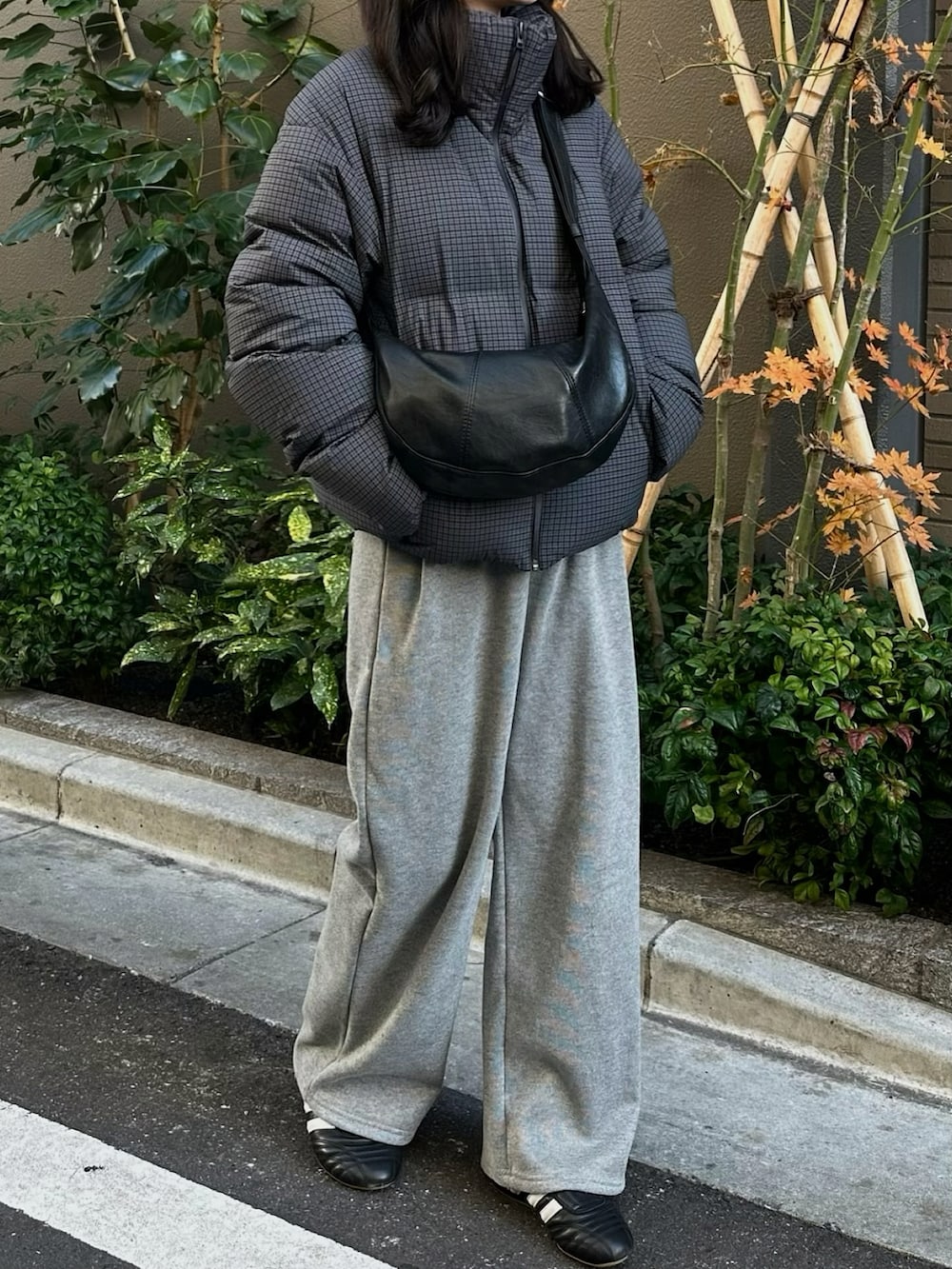 グレー系のスウェットパンツ、グレー系のダウンジャケット/コート、ブラック系のショルダーバッグを着用したレディースの冬コーディネートの2枚目の写真