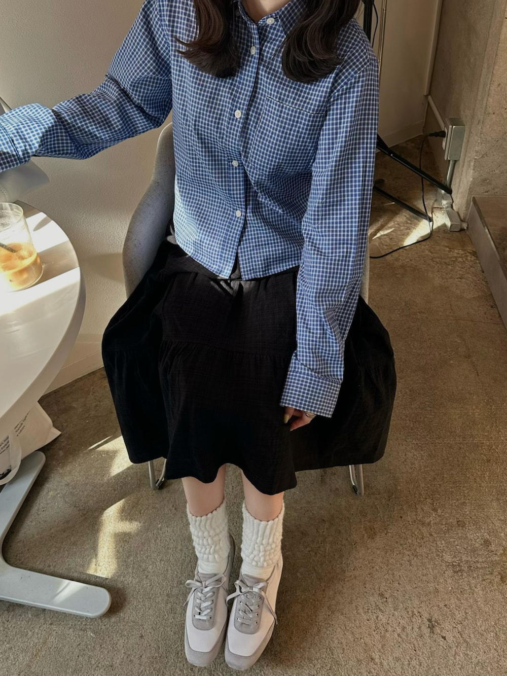 ブルー系のシャツ/ブラウス、ブラック系のスカート、グレー系のバレエシューズを着用したレディースの春コーディネートの2枚目の写真