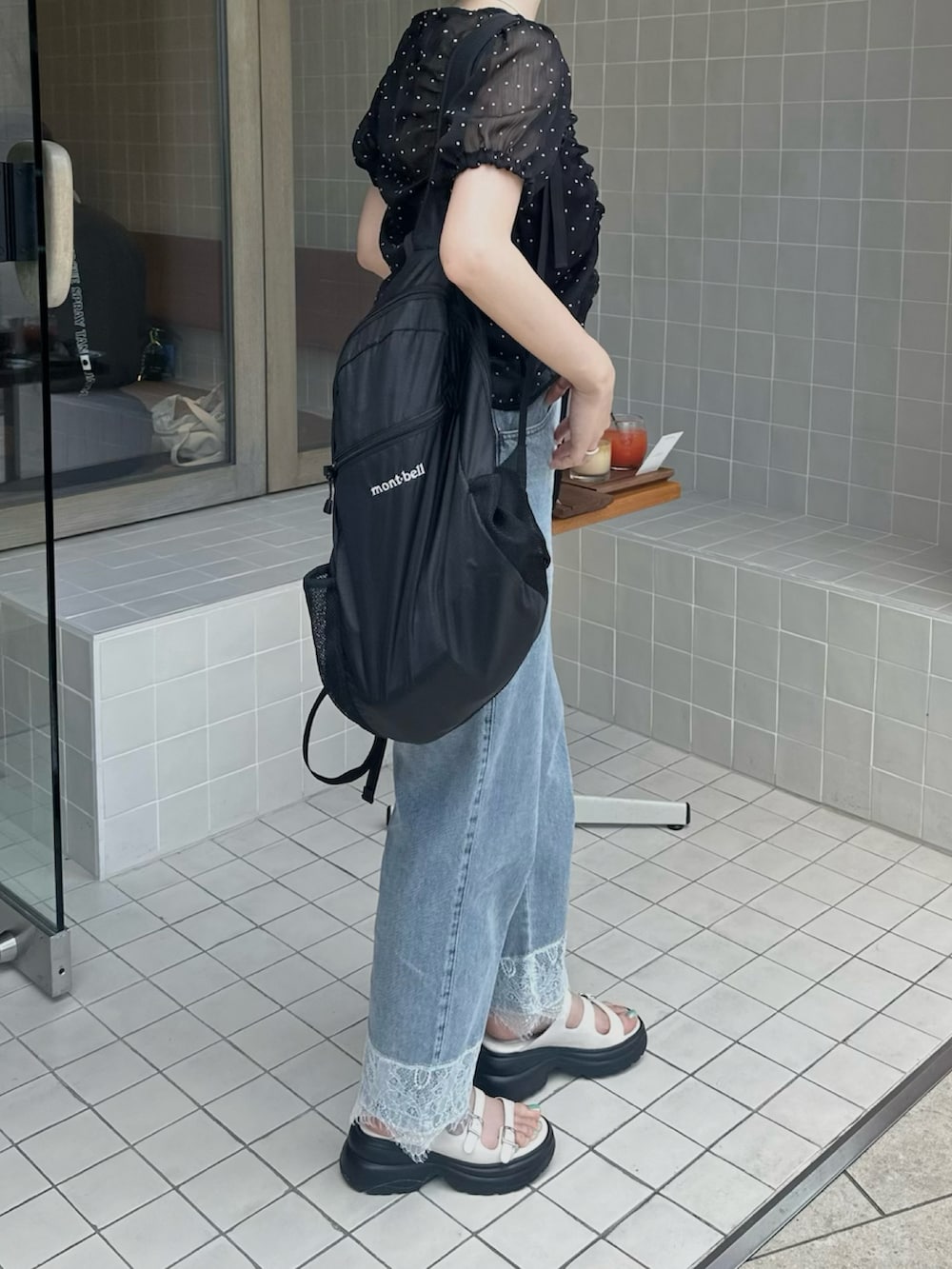 ブラック系のシャツ/ブラウス、ブルー系のデニムパンツ、ブラック系のバックパック/リュックを着用したレディースの夏コーディネートの2枚目の写真