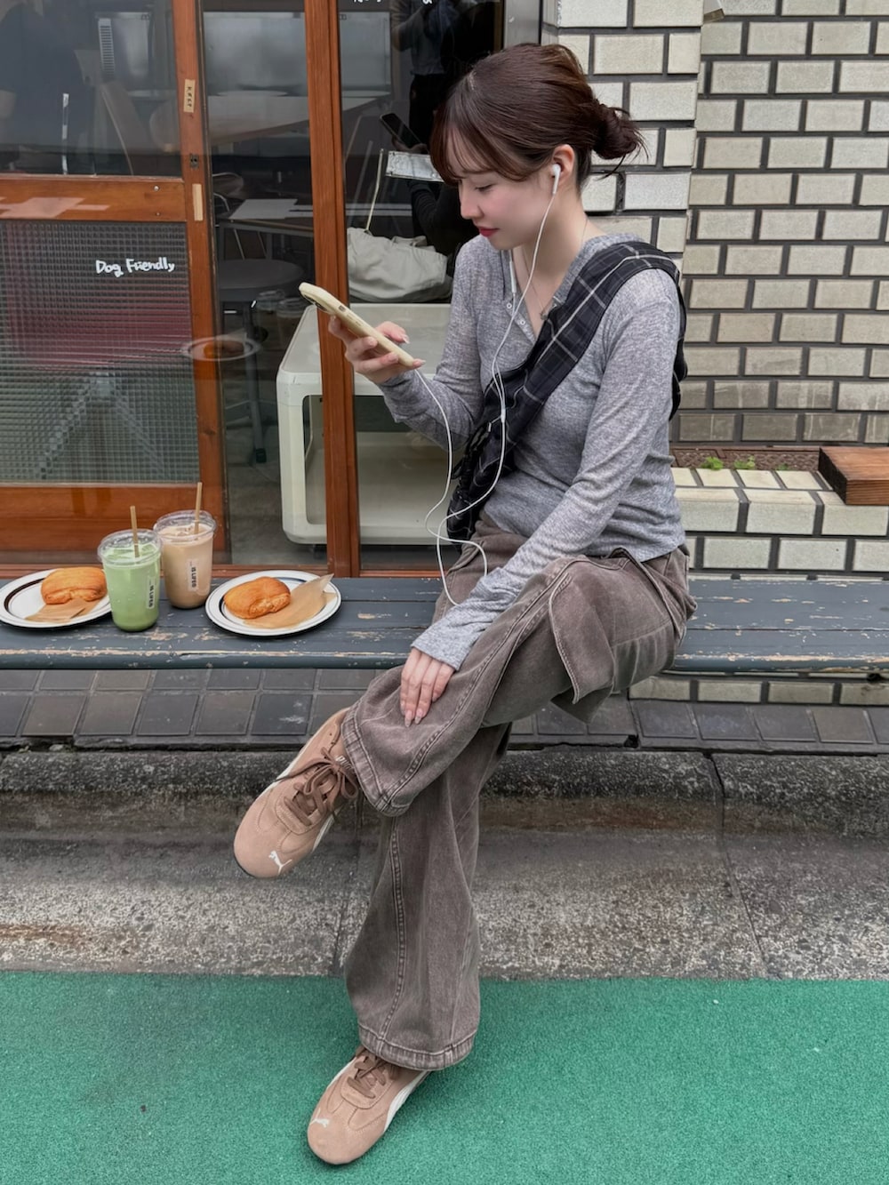 グレー系のTシャツ/カットソー、ブラウン系のデニムパンツ、ブラック系のショルダーバッグを着用したレディースの夏コーディネートの2枚目の写真