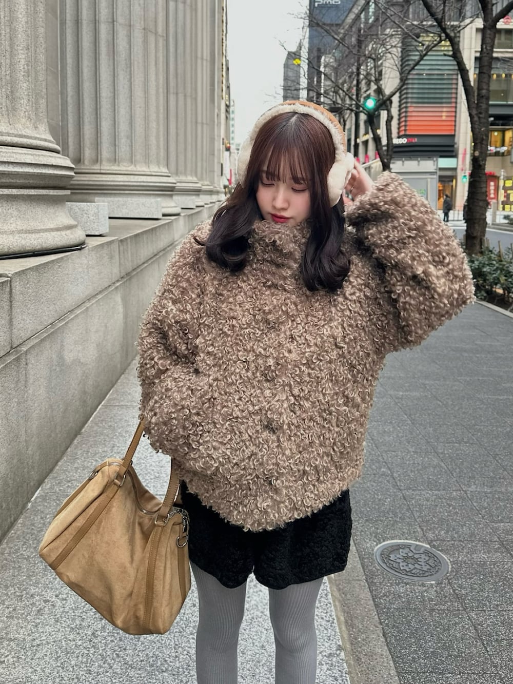 ベージュ系のブルゾン、ベージュ系のショルダーバッグ、ブラック系のスニーカーを着用したレディースの冬コーディネートの2枚目の写真