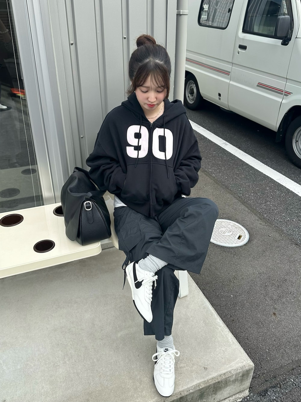 ブラック系のパーカー、ホワイト系のスニーカー、グレー系のカーゴパンツを着用したレディースの秋コーディネートの2枚目の写真