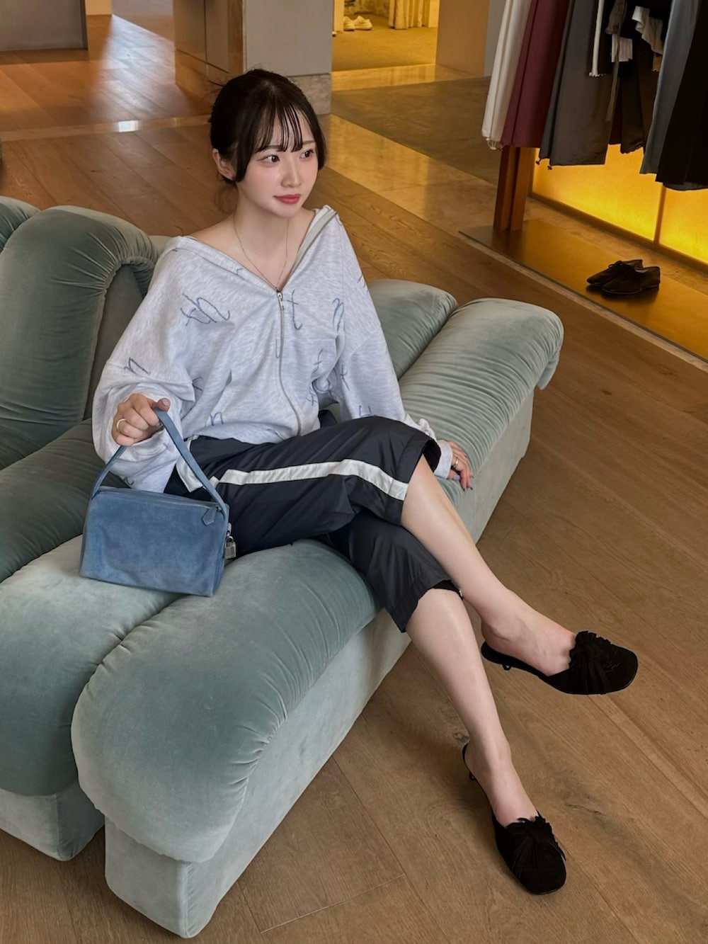 グレー系のパーカー、ブラック系のパンツ、ブラック系のパンプスを着用したレディースの夏コーディネートの2枚目の写真