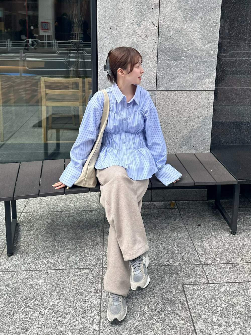 ブルー系のシャツ/ブラウス、ベージュ系のスウェットパンツ、ベージュ系のバッグを着用したレディースの春コーディネートの2枚目の写真