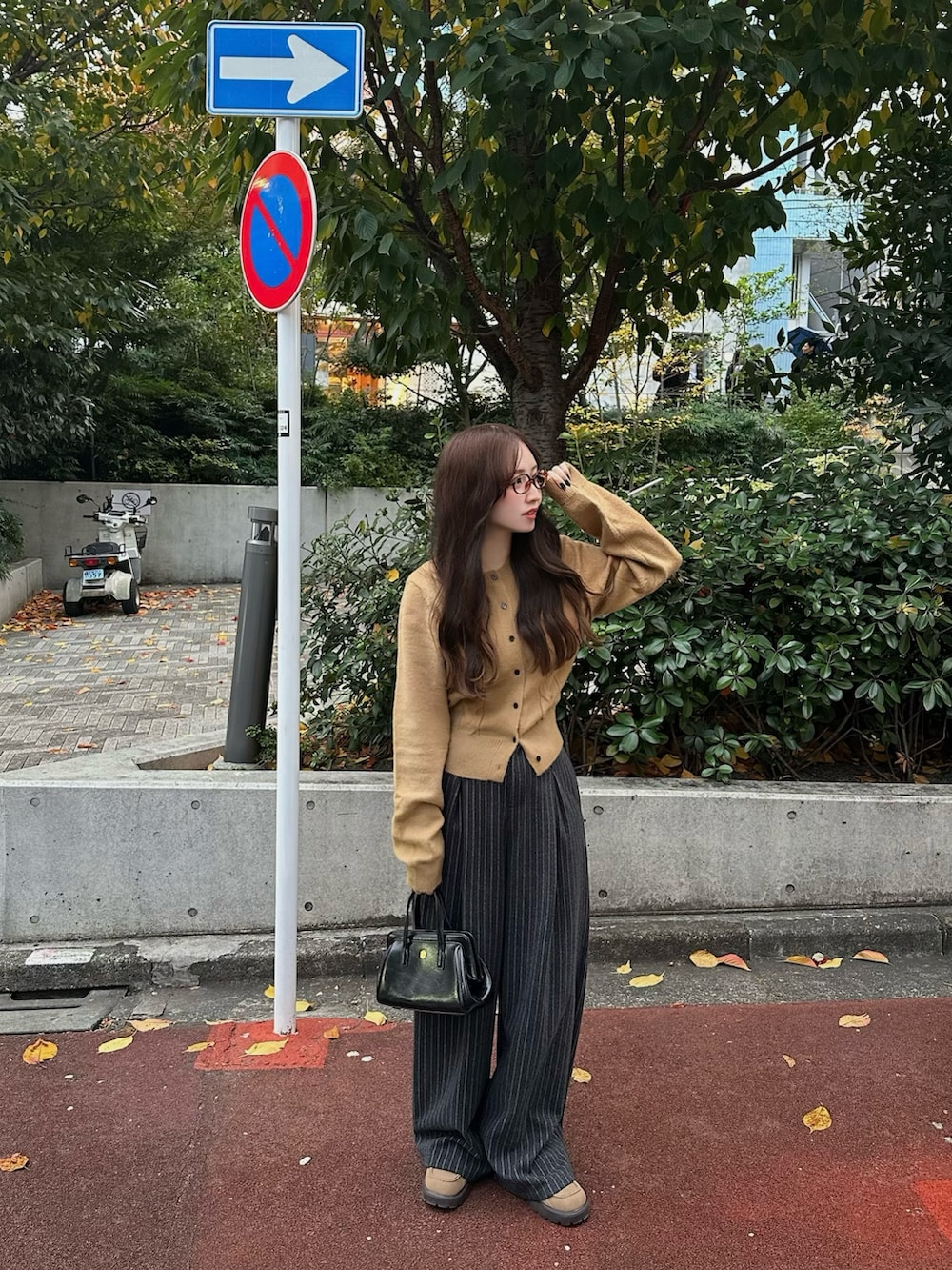 グレー系のスラックス、ベージュ系のカーディガン/ボレロ、ベージュ系のローファーを着用したレディースの秋コーディネートの2枚目の写真