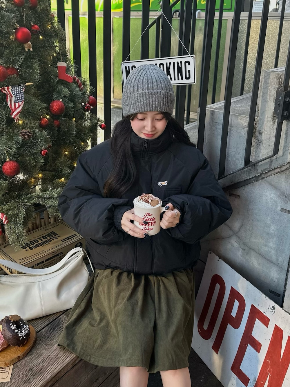 ブラック系のダウンジャケット/コート、グリーン系のスカート、グレー系のニットキャップ/ビーニーを着用したレディースの冬コーディネートの2枚目の写真