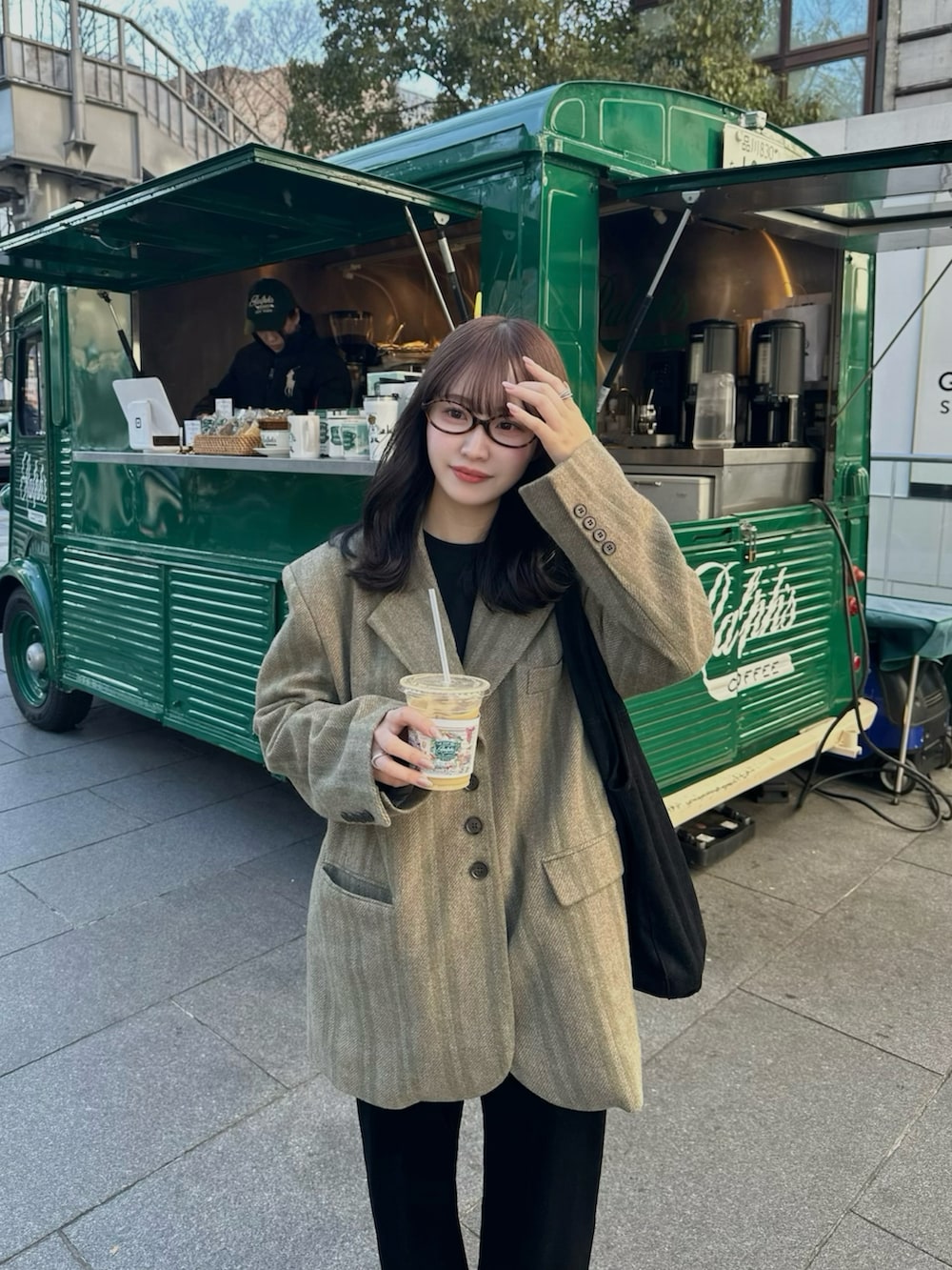 グリーン系のその他アウター、ブラック系のパンツ、ベージュ系のスニーカーを着用したレディースの冬コーディネートの2枚目の写真