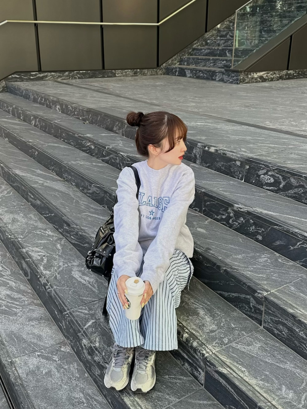 ブルー系のカーゴパンツ、ブラック系のショルダーバッグ、グレー系のトップスを着用したレディースの春コーディネートの2枚目の写真