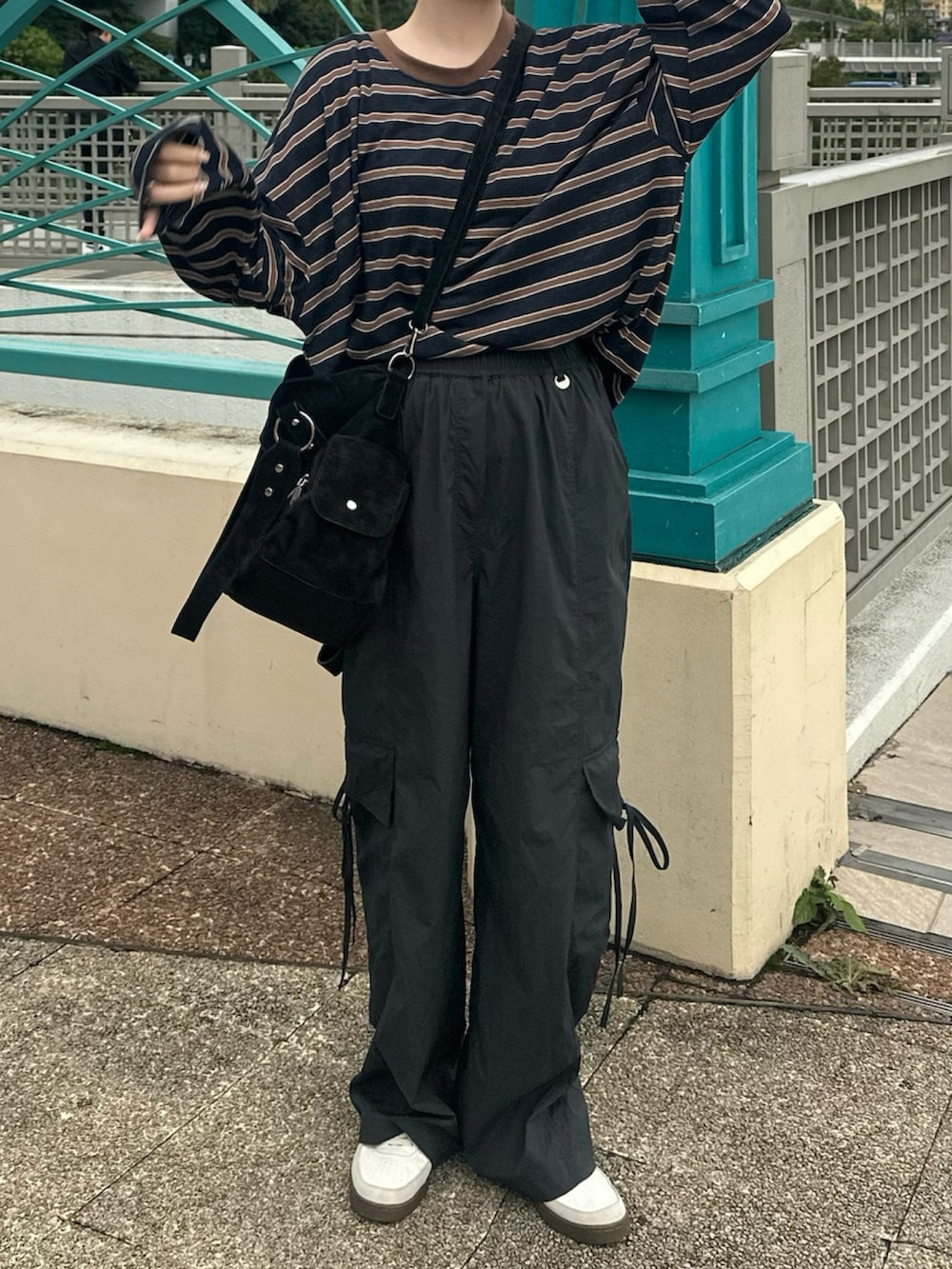 ブルー系のTシャツ/カットソー、ブラック系のトートバッグ、ホワイト系のスニーカーを着用したレディースの秋コーディネートの2枚目の写真