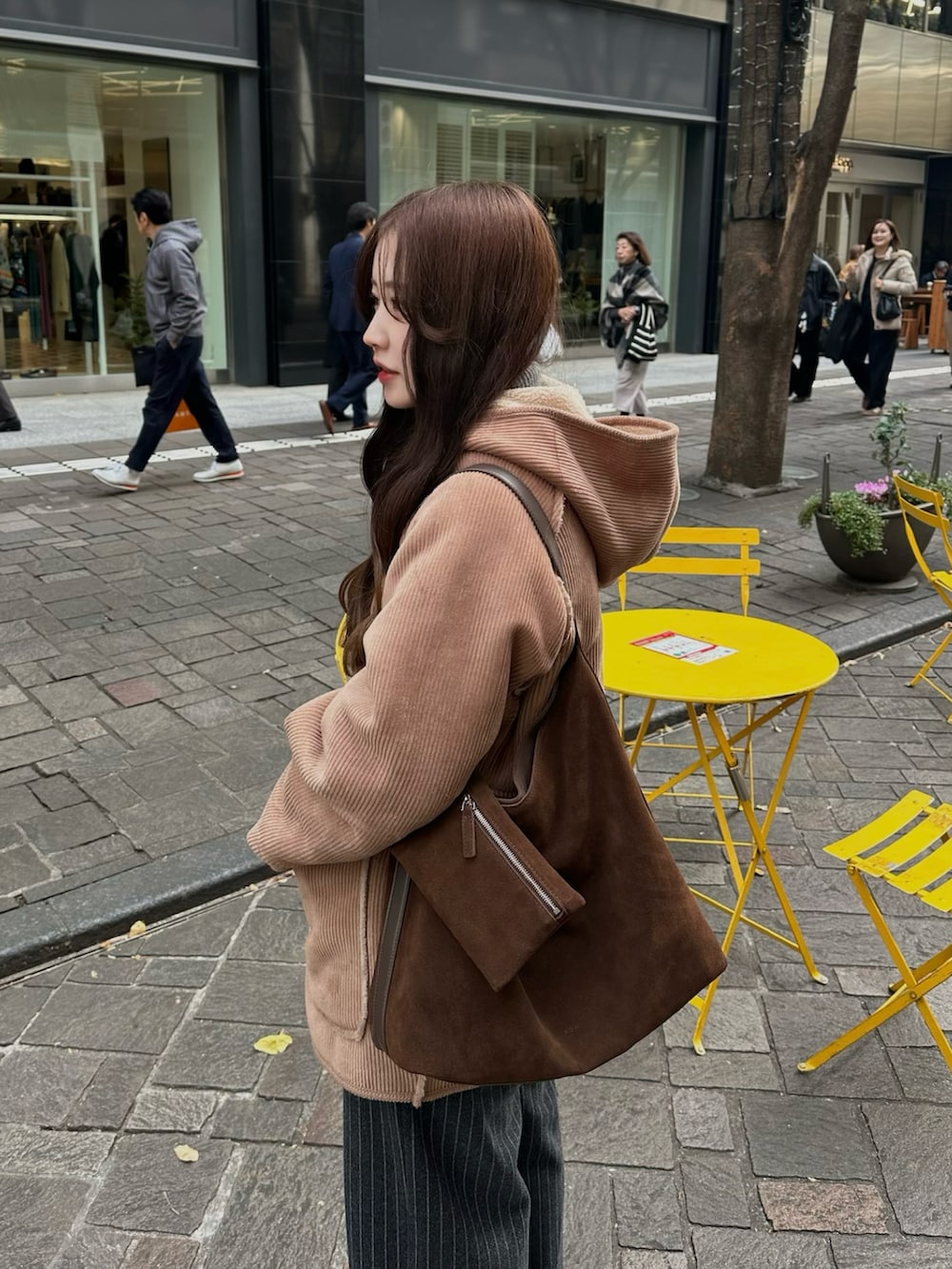 グレー系のスラックス、ベージュ系のブーツ、ブラウン系のジャケット/アウターを着用したレディースの冬コーディネートの2枚目の写真