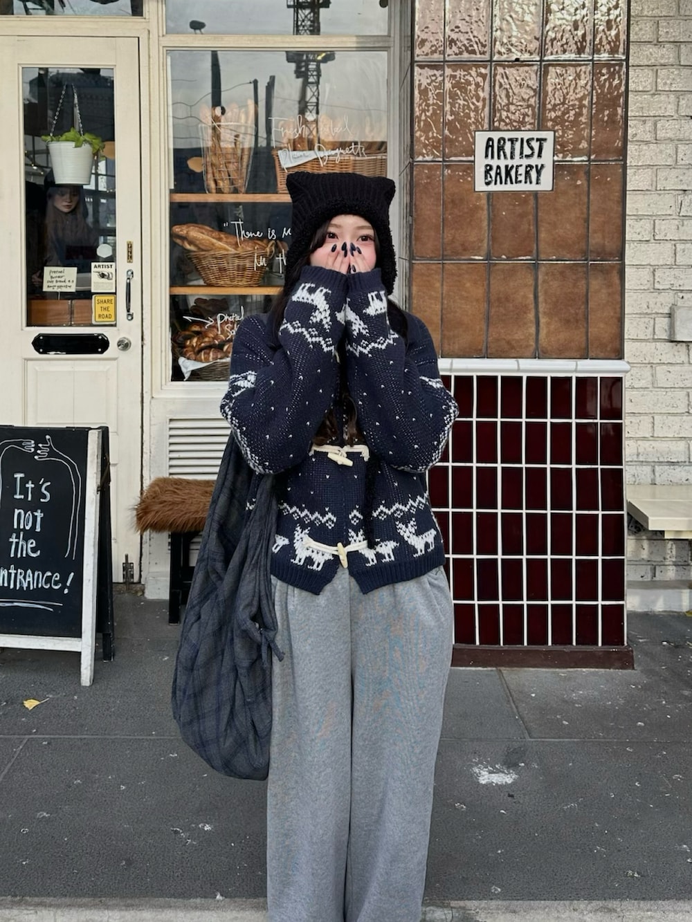 グレー系のトートバッグ、グレー系のスウェットパンツ、ブルー系のカーディガン/ボレロを着用したレディースの冬コーディネートの2枚目の写真