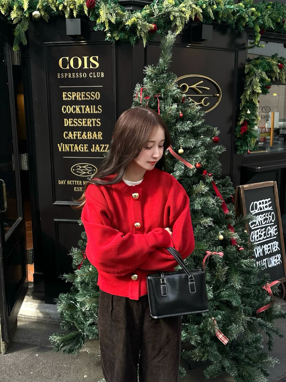 レッド系のカーディガン/ボレロ、ブラウン系のチノパンツ、ブラック系のローファーを着用したレディースの秋コーディネートの2枚目の写真