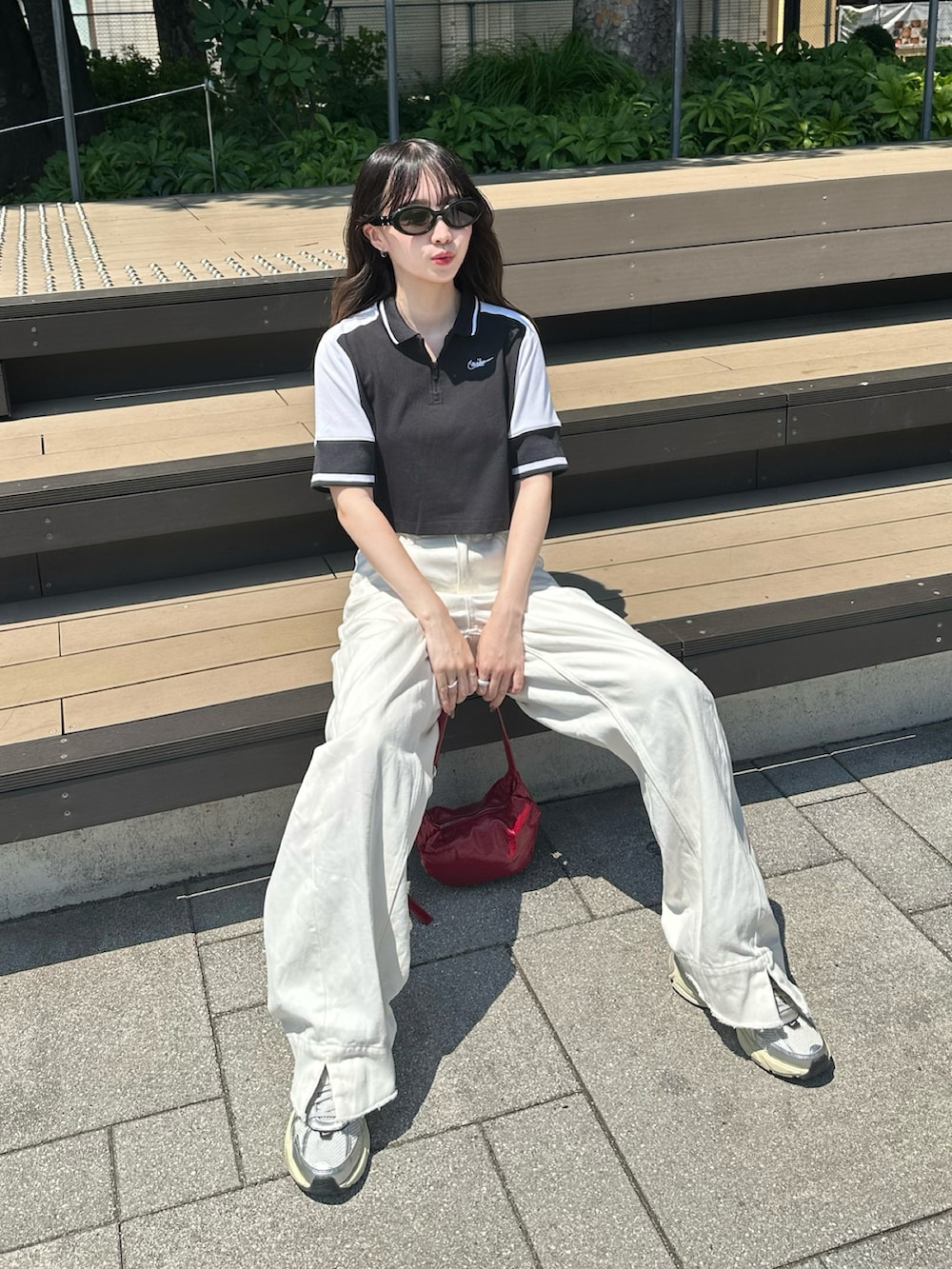 ホワイト系のスニーカー、ブラック系のトップス、ホワイト系のデニムパンツを着用したレディースの夏コーディネートの2枚目の写真