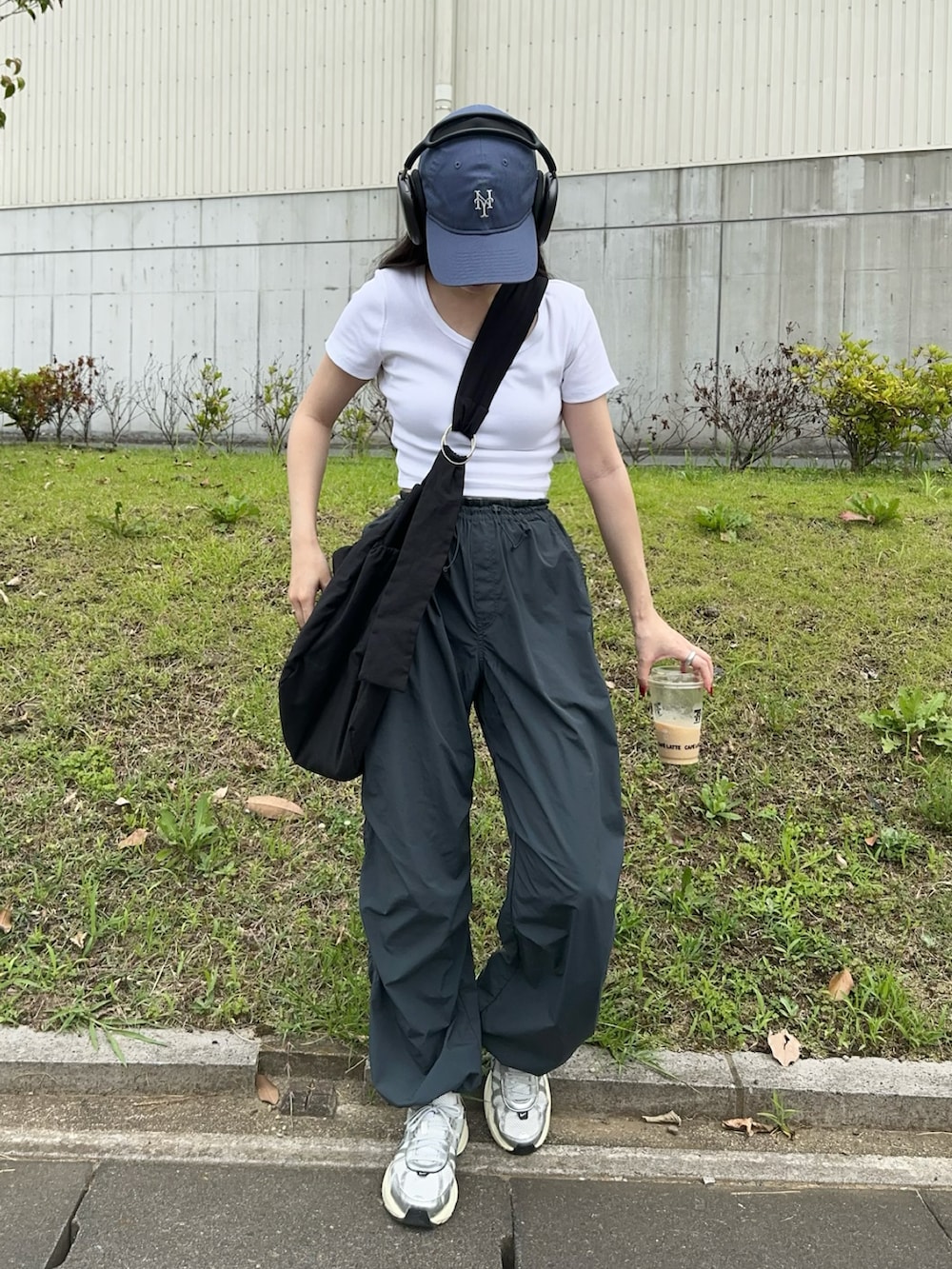 ホワイト系のスニーカー、ホワイト系のTシャツ/カットソー、グレー系のパンツを着用したレディースの夏コーディネートの2枚目の写真