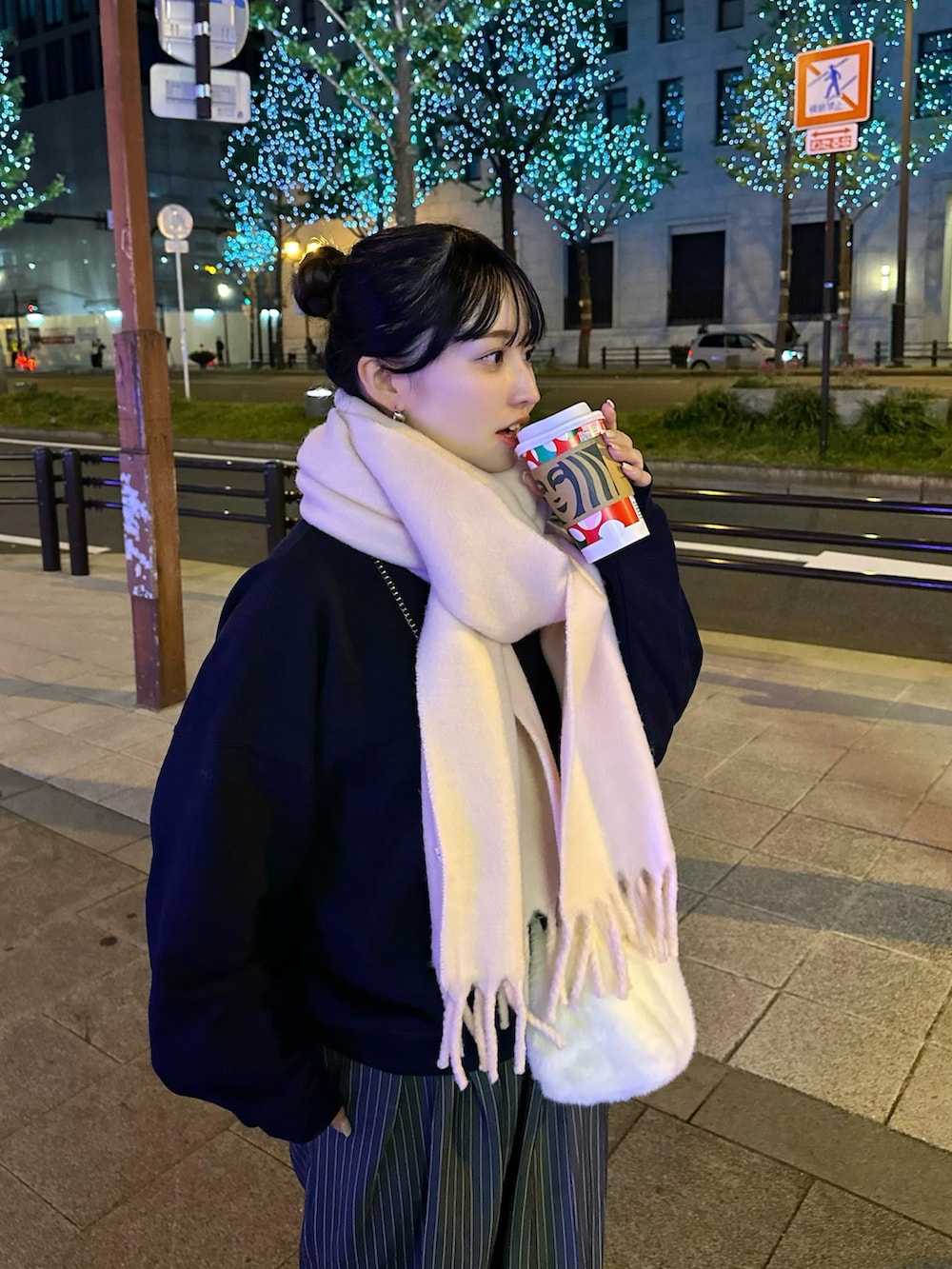 ブルー系のスウェット、ブルー系のスラックス、ピンク系のマフラーを着用したレディースの秋コーディネートの2枚目の写真