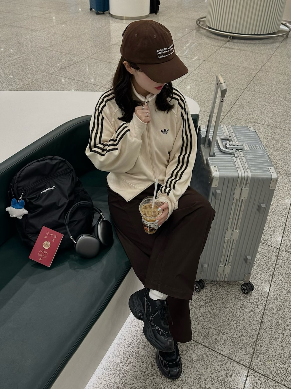 ブラック系のスニーカー、ホワイト系のジャケット/アウター、ブラウン系のパンツを着用したレディースの春コーディネートの2枚目の写真