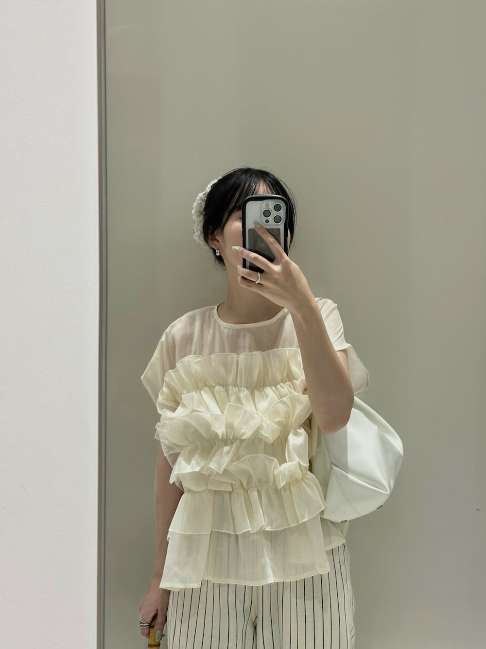 ホワイト系のトップス、ベージュ系のパンツを着用したレディースの夏コーディネートの2枚目の写真