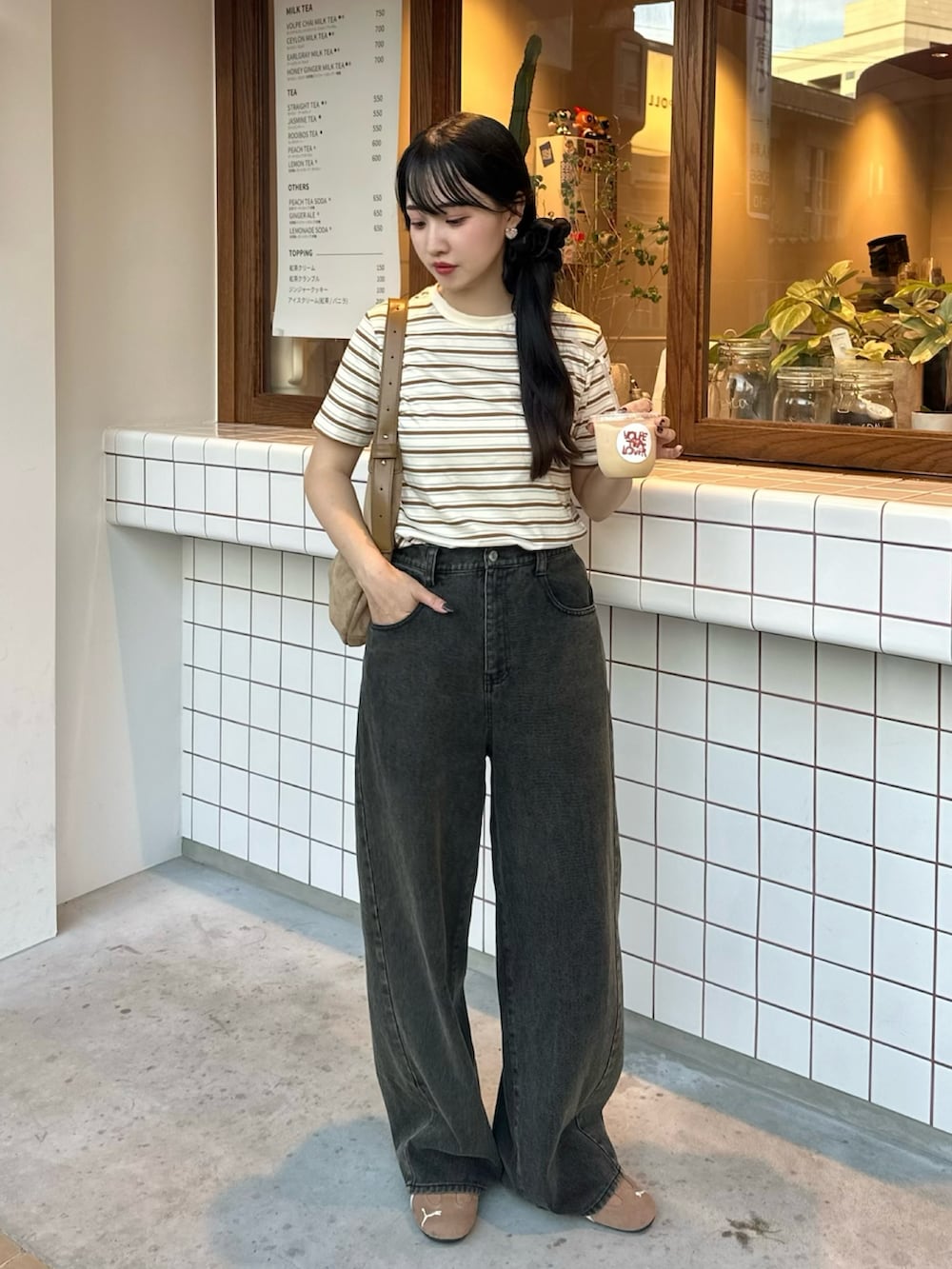 ベージュ系のTシャツ/カットソー、グレー系のデニムパンツ、ブラウン系のスニーカーを着用したレディースの夏コーディネートの2枚目の写真