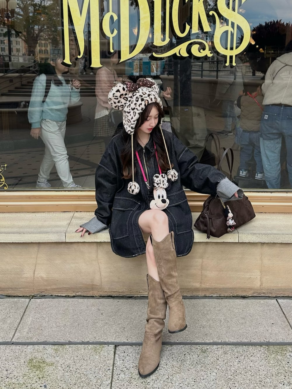 ブラック系のデニムジャケット、ブラウン系のボストンバッグを着用したレディースの秋コーディネートの2枚目の写真