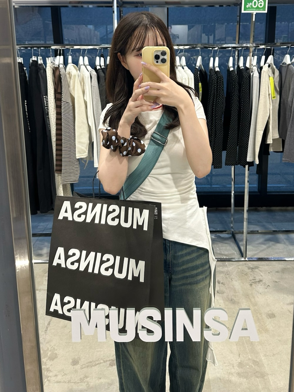 ブルー系のデニムパンツ、ブルー系のスニーカー、ホワイト系のTシャツ/カットソーを着用したレディースの夏コーディネートの2枚目の写真