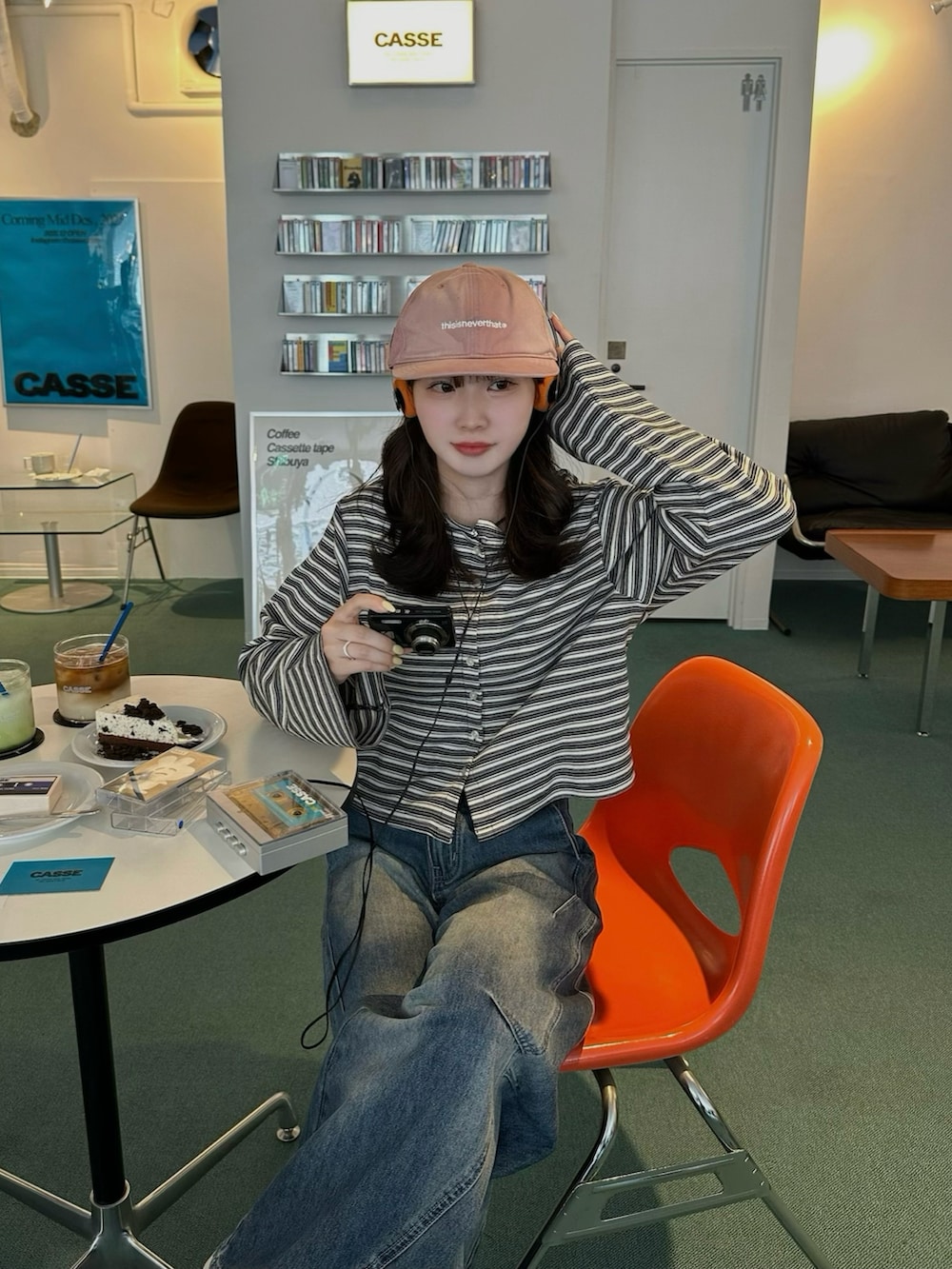 ブラック系のショルダーバッグ、グレー系のカーディガン/ボレロ、ブルー系のデニムパンツを着用したレディースの春コーディネートの2枚目の写真