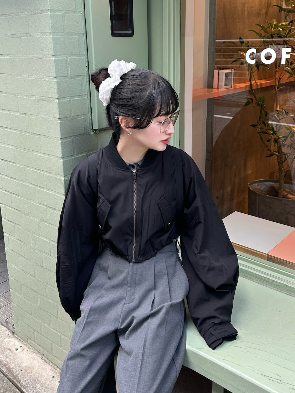 ブラック系のスニーカー、ブラック系のジャケット/アウター、グレー系のパンツを着用したレディースの春コーディネートの2枚目の写真