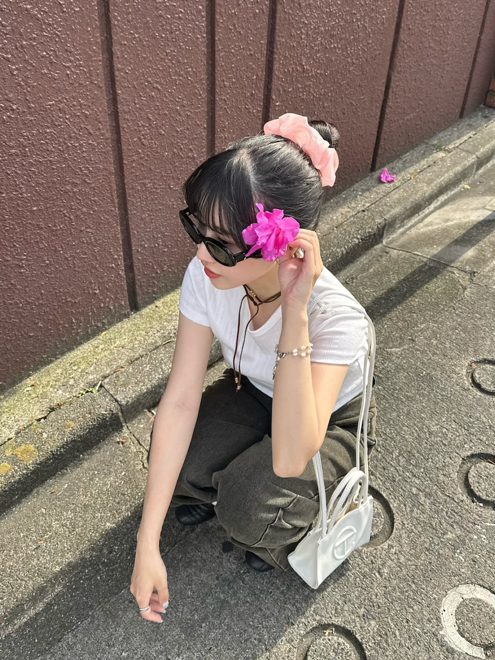 ブラック系のスニーカー、ホワイト系のTシャツ/カットソー、グレー系のデニムパンツを着用したレディースの春コーディネートの2枚目の写真