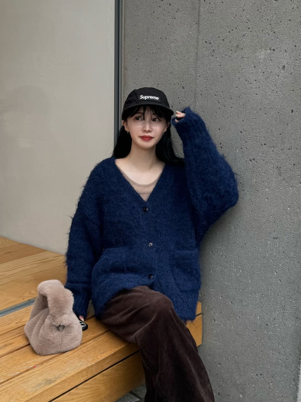 ブルー系のカーディガン/ボレロ、ブラウン系のその他パンツ、ホワイト系のスニーカーを着用したレディースの秋コーディネートの2枚目の写真