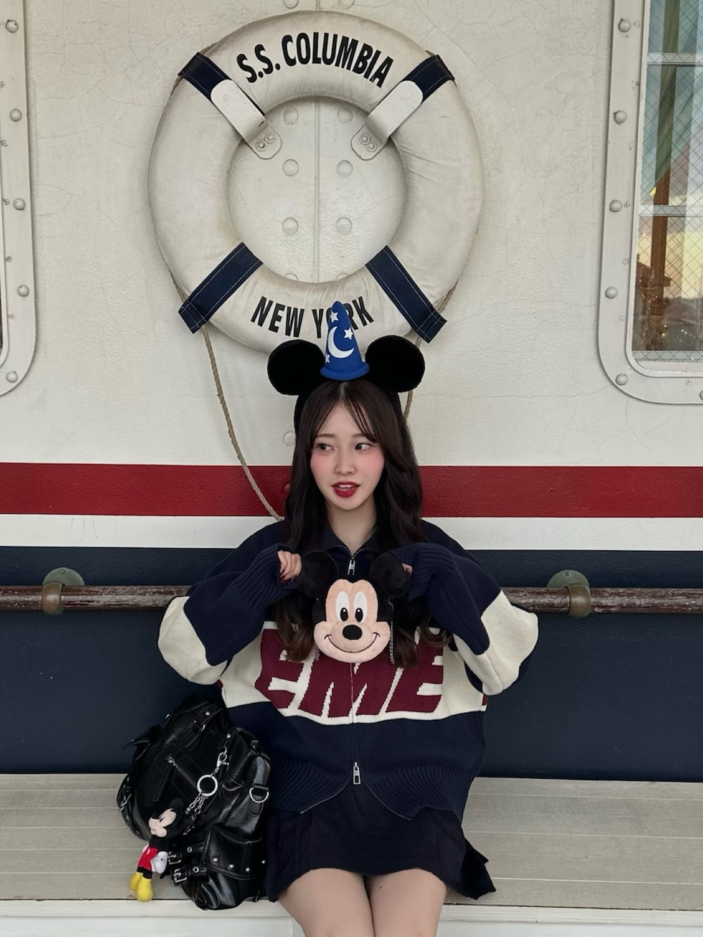 ブラック系のショルダーバッグ、ブラック系のスニーカー、ブルー系のニット/セーターを着用したレディースの秋コーディネートの2枚目の写真