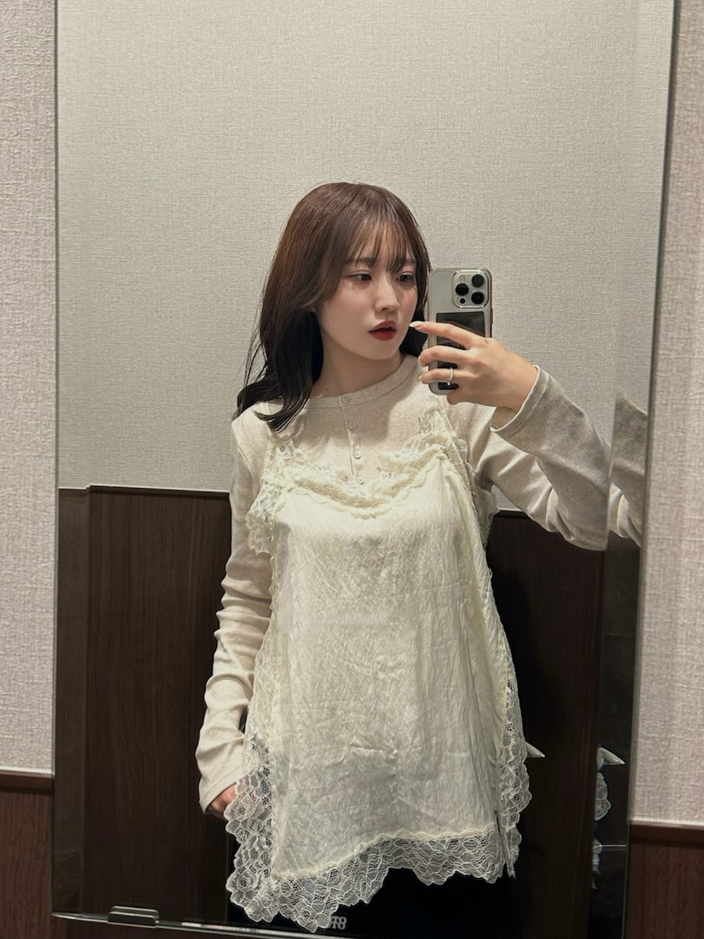 ホワイト系のキャミソール、ベージュ系のトップス、ブラック系のパンツを着用したレディースの春コーディネートの2枚目の写真