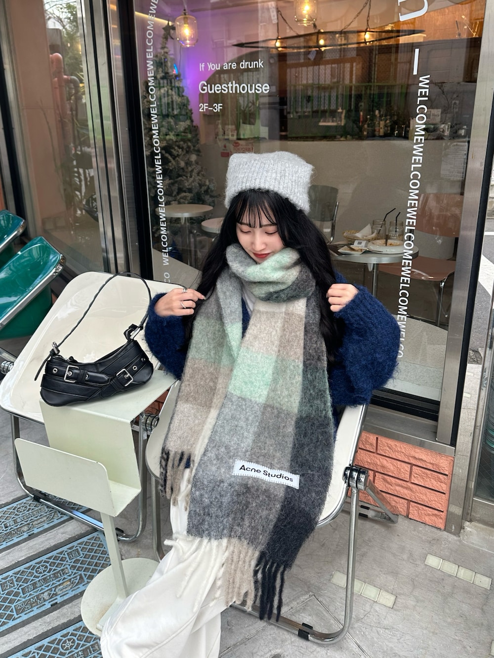 ホワイト系のスウェットパンツ、グリーン系のマフラーを着用したレディースの秋コーディネートの2枚目の写真