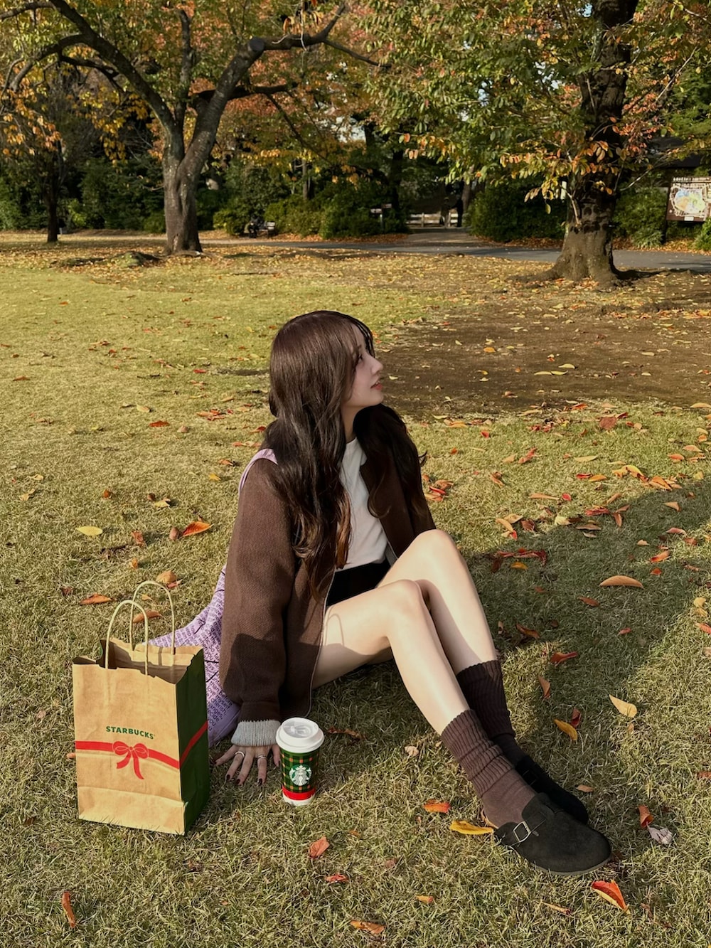 ブラウン系のカーディガン/ボレロ、ブラック系のスリッポンを着用したレディースの秋コーディネートの2枚目の写真