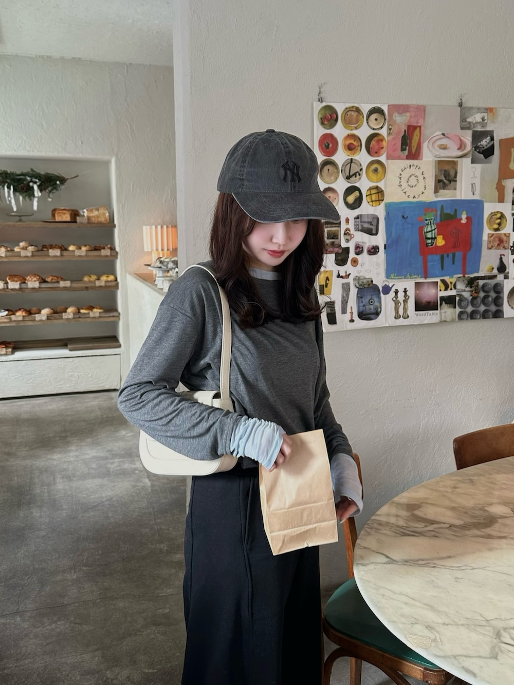 グレー系のトップス、ブラック系のスウェットパンツ、グレー系のキャップを着用したレディースの冬コーディネートの2枚目の写真